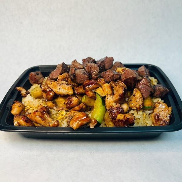 Shinrai Japanese Bistro's hibachi chicken and steak with fried rice and vegetables in a black container.